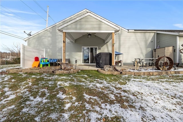 snow covered rear of property featuring ceiling fan