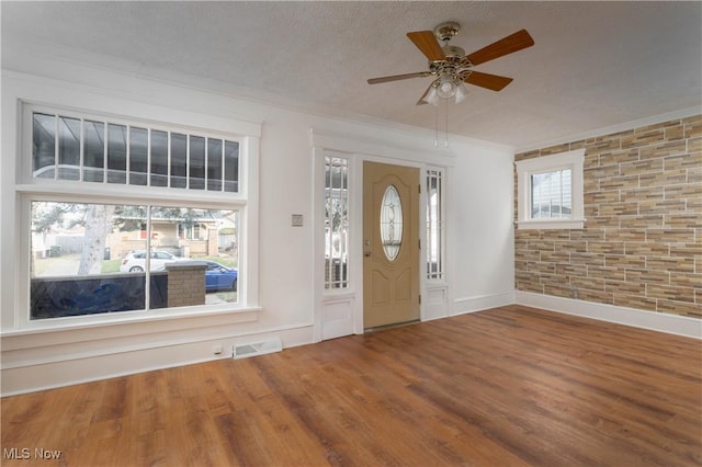 entryway with crown molding, hardwood / wood-style floors, ceiling fan, and a textured ceiling