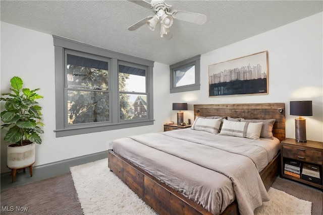 bedroom with ceiling fan and a textured ceiling