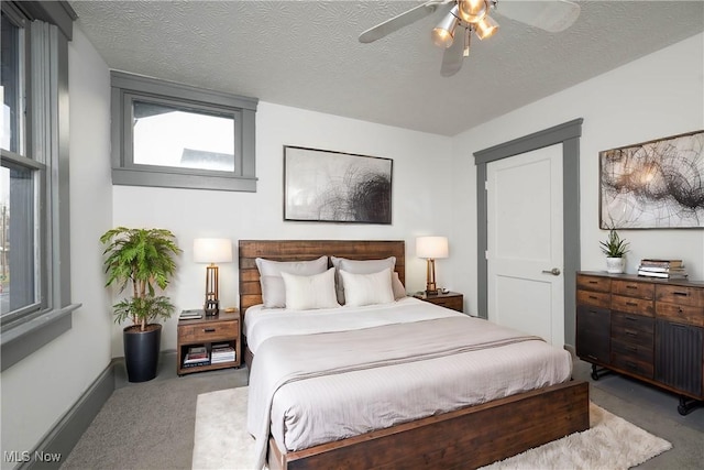 bedroom with light carpet, ceiling fan, and a textured ceiling