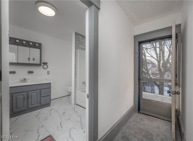 bathroom with vanity, toilet, and a textured ceiling