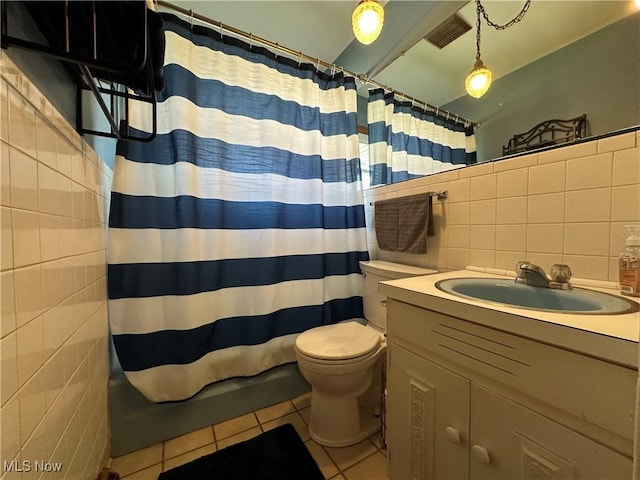 bathroom with toilet, tile walls, vanity, a shower with shower curtain, and tile patterned flooring