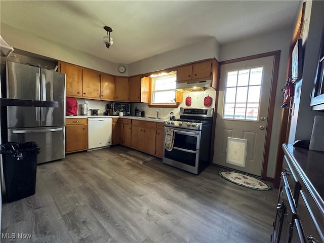 kitchen featuring stainless steel appliances, hardwood / wood-style floors, and backsplash