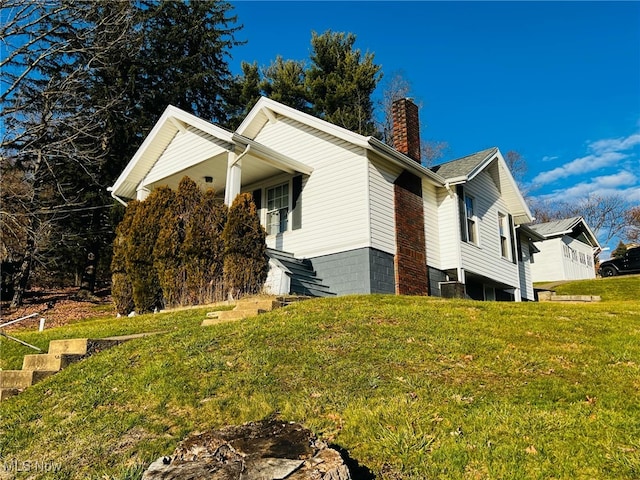 view of side of home with a yard