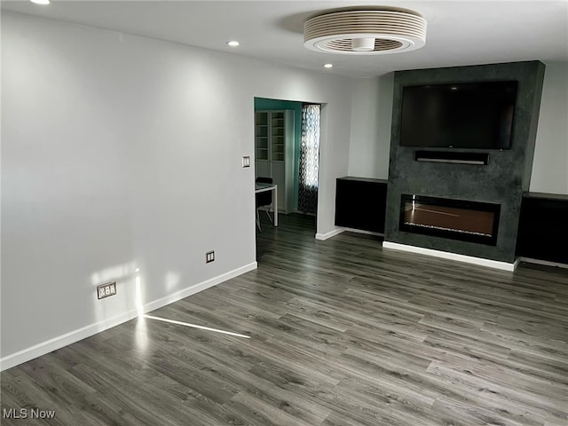 unfurnished living room with wood-type flooring and a large fireplace