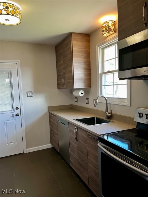 kitchen featuring dark tile patterned flooring, sink, and stainless steel appliances