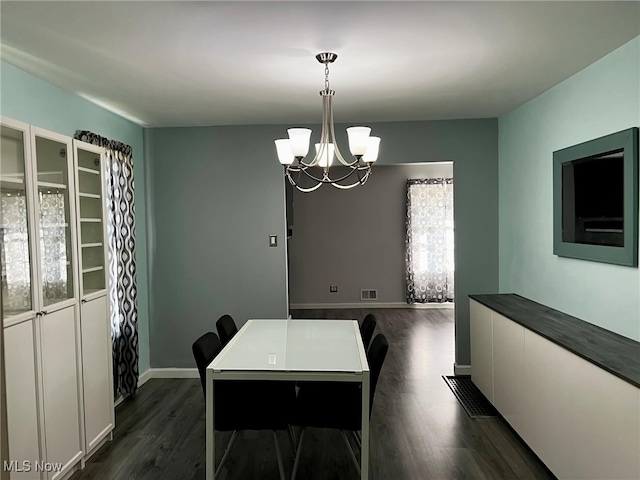 dining room with a chandelier and dark hardwood / wood-style flooring