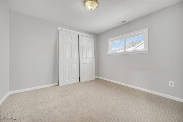 unfurnished bedroom featuring carpet and a closet