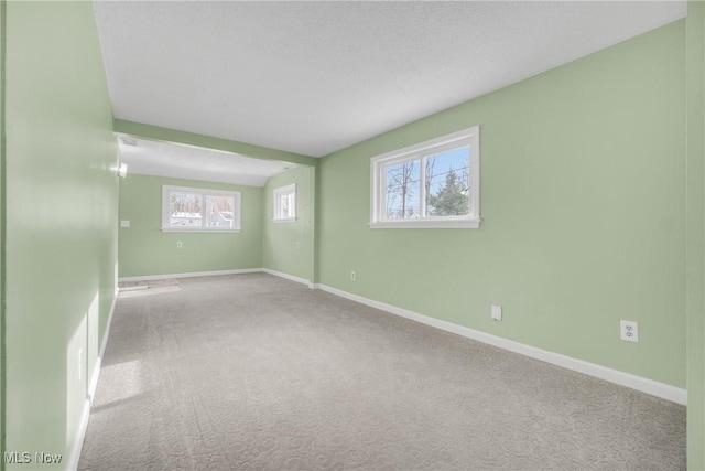 carpeted spare room featuring baseboards