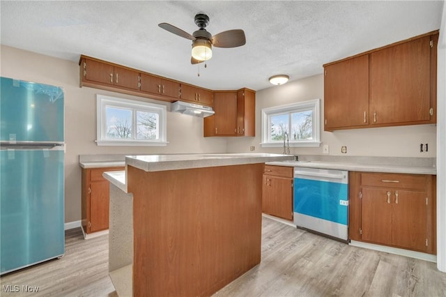 kitchen with dishwasher, under cabinet range hood, light wood-style floors, and freestanding refrigerator