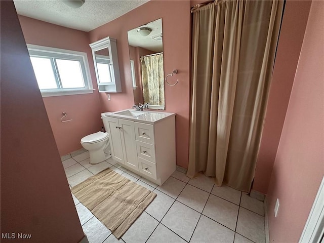 bathroom featuring tile patterned floors, a textured ceiling, vanity, and toilet