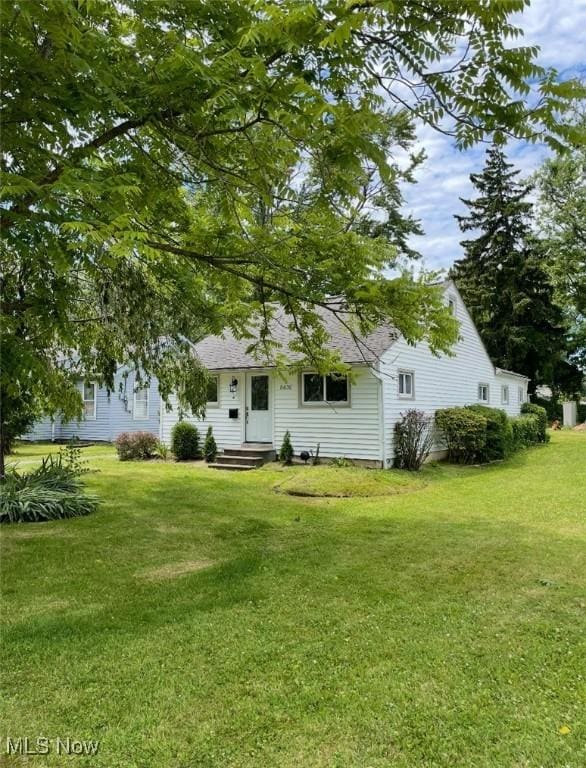 view of front of home featuring entry steps and a front lawn