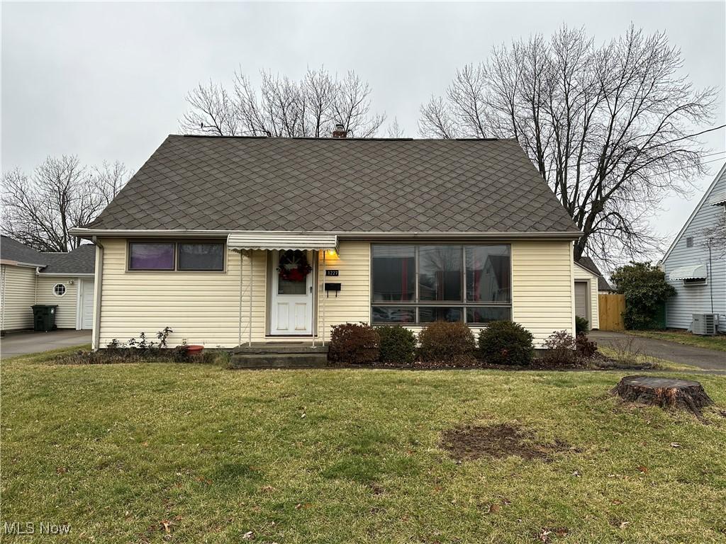 view of front of house with a front yard and central AC