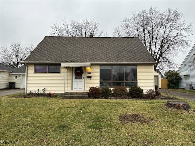 view of front of house with a front yard and central AC