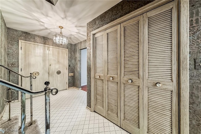 interior space with an inviting chandelier and wallpapered walls