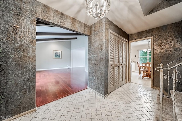 hallway with an inviting chandelier, beamed ceiling, wood finished floors, and baseboards