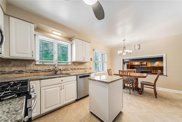 kitchen with decorative backsplash, white cabinetry, stainless steel appliances, and decorative light fixtures