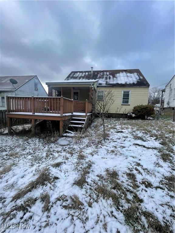 snow covered house with a deck