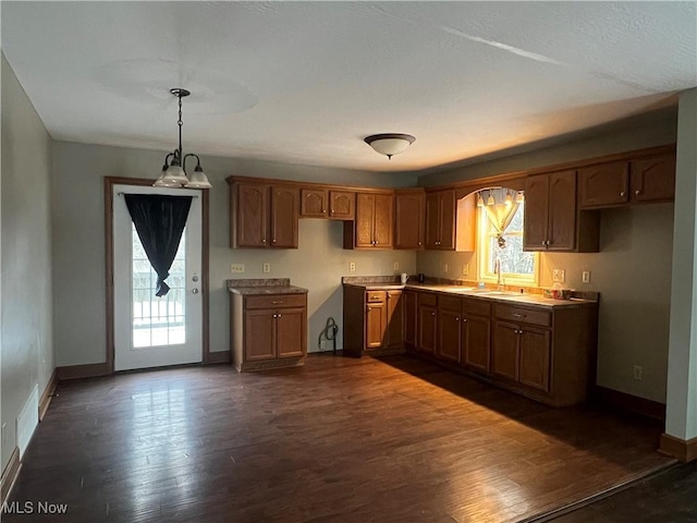 kitchen with a healthy amount of sunlight, sink, pendant lighting, and dark hardwood / wood-style floors