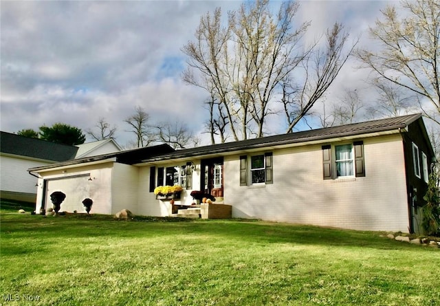 back of house with a yard and a garage