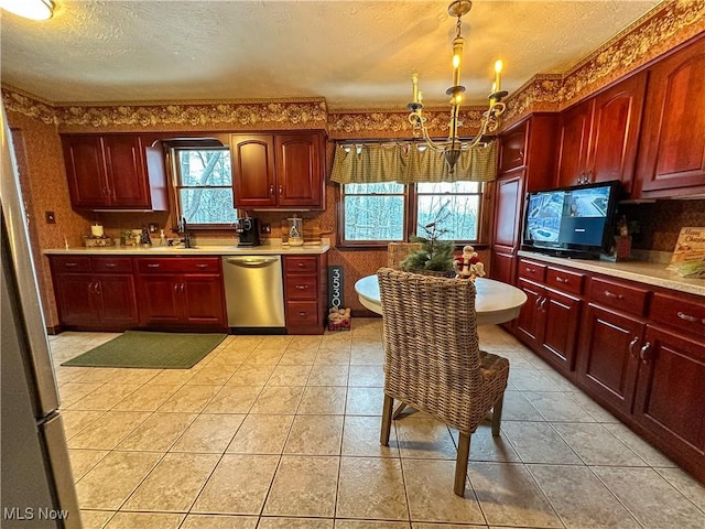 kitchen with pendant lighting, stainless steel dishwasher, a wealth of natural light, and sink