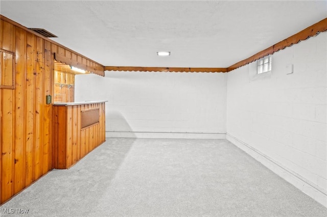 carpeted spare room with wood walls