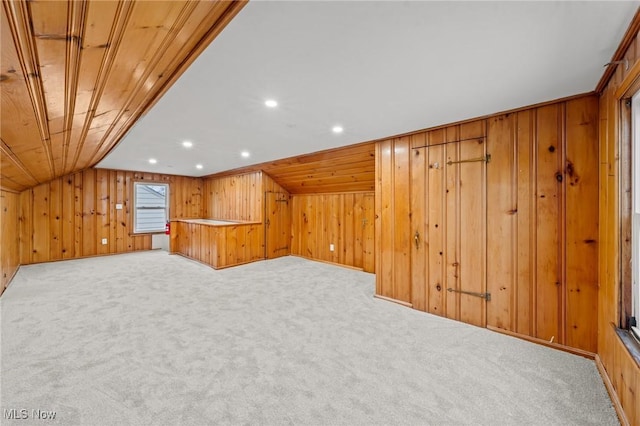 bonus room with wooden ceiling, wooden walls, light colored carpet, and lofted ceiling