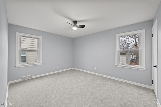 carpeted spare room featuring ceiling fan