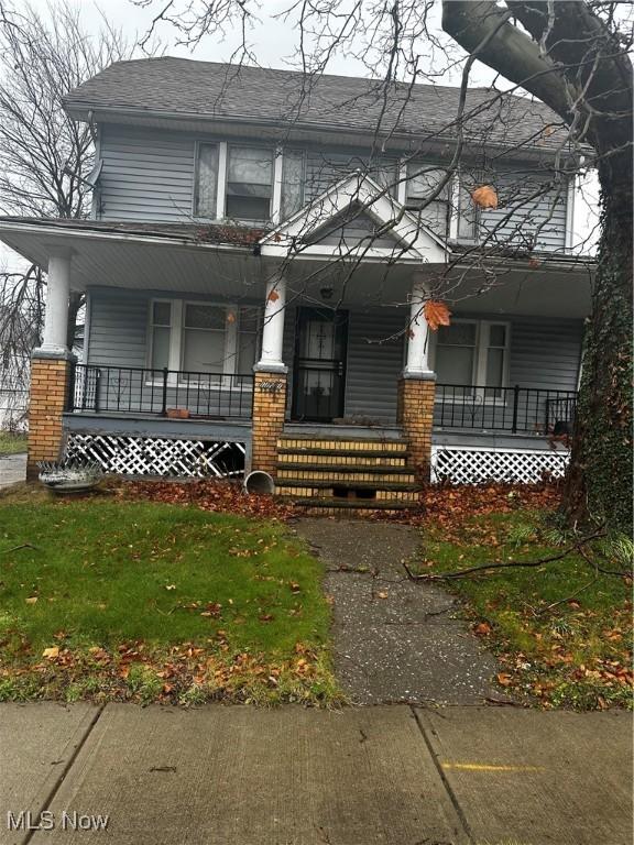 view of front of property with a porch and a front lawn