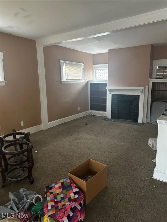 unfurnished living room featuring dark carpet