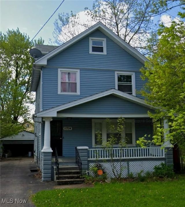 view of front of property with a porch, a garage, and an outdoor structure