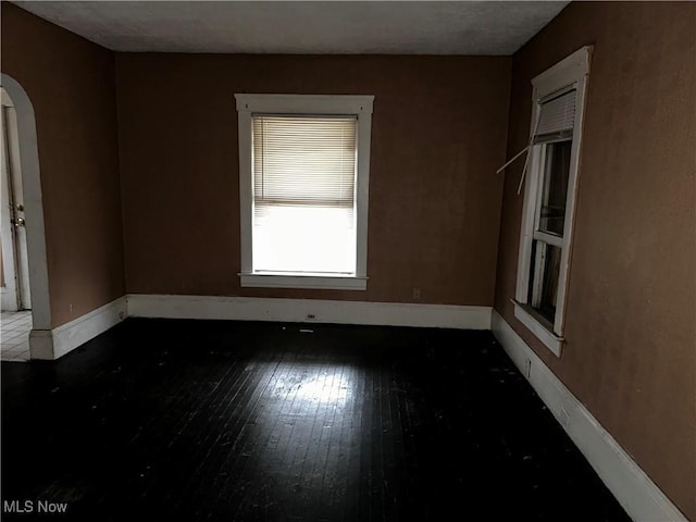 unfurnished room with dark wood-type flooring