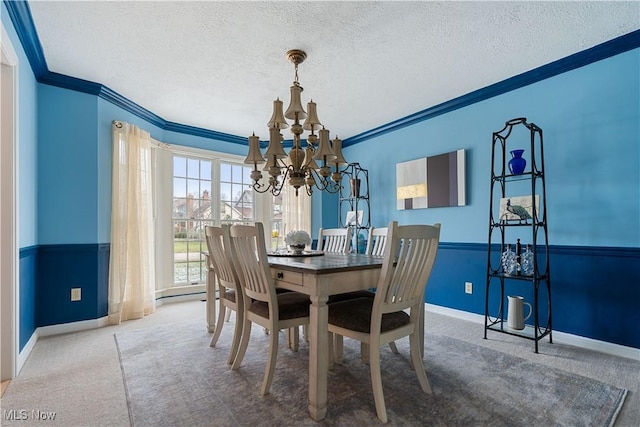 dining space featuring carpet flooring, a notable chandelier, ornamental molding, and a textured ceiling