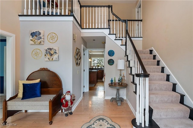 foyer entrance featuring hardwood / wood-style floors and a towering ceiling