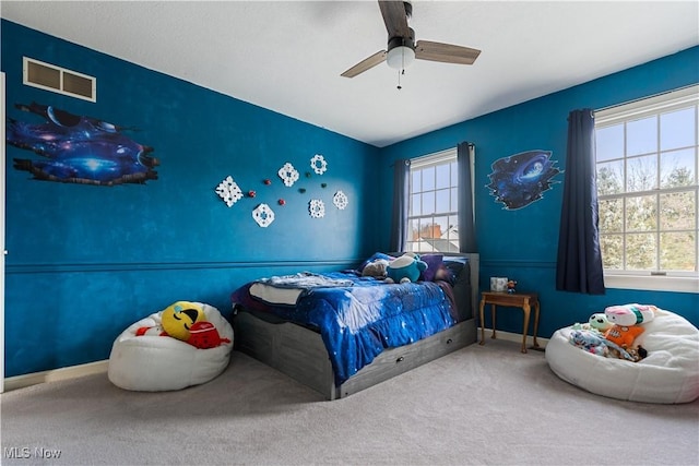 carpeted bedroom featuring ceiling fan and multiple windows