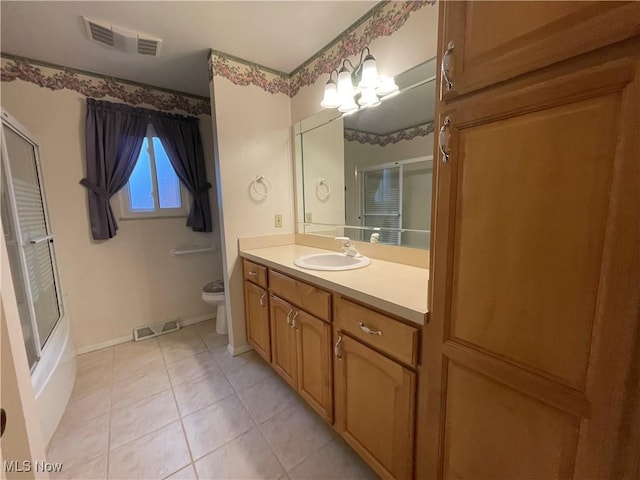 full bathroom featuring tile patterned floors, vanity, toilet, and enclosed tub / shower combo