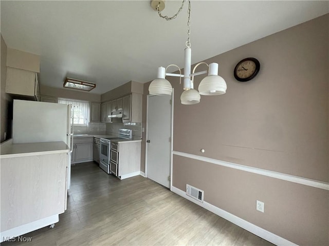 kitchen featuring backsplash, gray cabinetry, pendant lighting, electric range, and white fridge