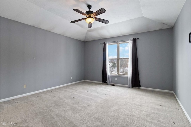 empty room featuring ceiling fan, lofted ceiling, and light carpet