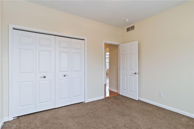 unfurnished bedroom with carpet flooring and a closet