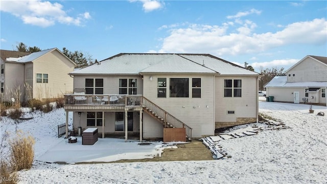 snow covered rear of property featuring a wooden deck