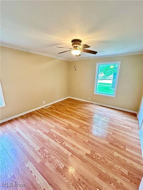 spare room featuring crown molding, light hardwood / wood-style flooring, and ceiling fan