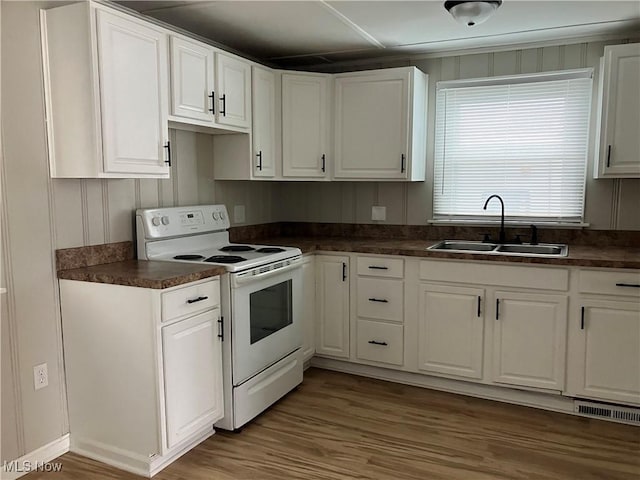 kitchen featuring white range with electric stovetop, white cabinetry, sink, and hardwood / wood-style floors