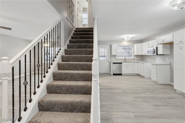 stairs featuring hardwood / wood-style floors and sink