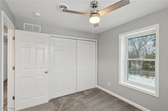 unfurnished bedroom with carpet, a closet, and ceiling fan