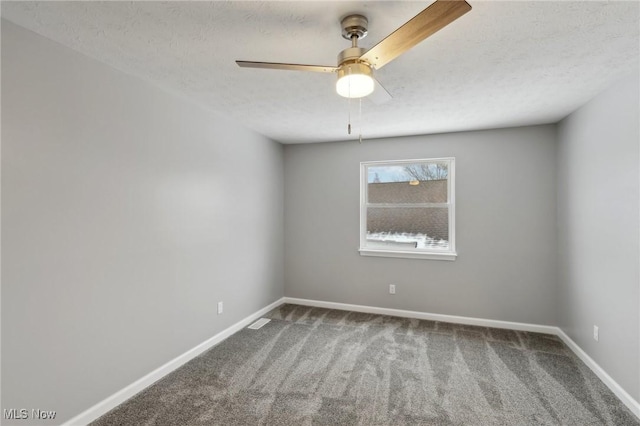 empty room with ceiling fan, carpet, and a textured ceiling