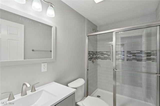 bathroom with vanity, toilet, and an enclosed shower