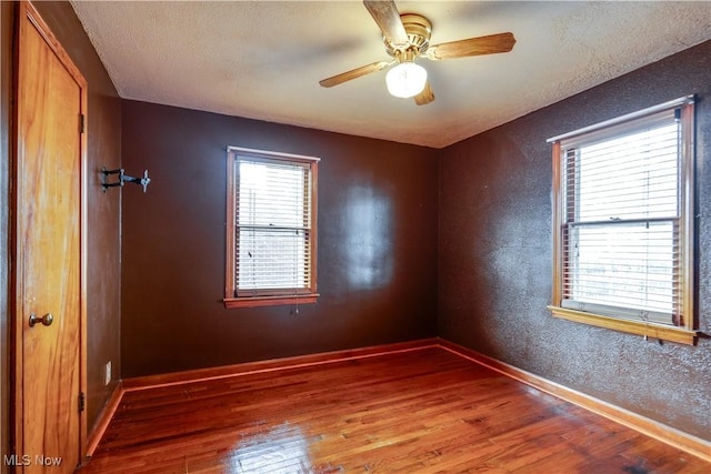 spare room featuring hardwood / wood-style floors, ceiling fan, and a textured ceiling