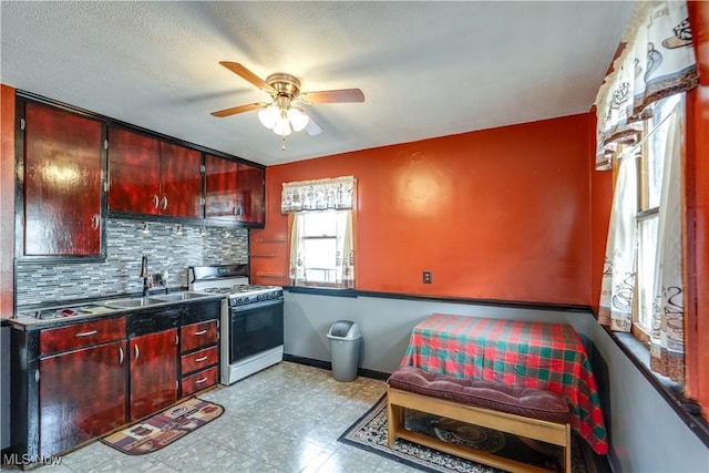 kitchen featuring backsplash, ceiling fan, sink, and white gas range oven