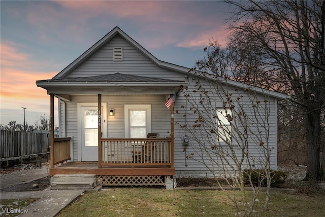 bungalow-style home featuring a lawn and a porch