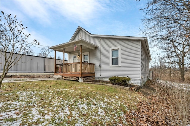 back of property featuring a porch and a yard